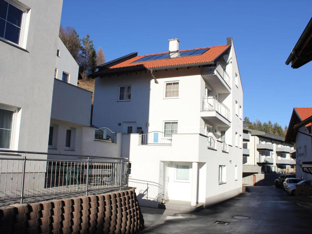ein weißes Apartmenthaus mit rotem Dach in der Unterkunft Modern Apartment in Fiss at Ski Bus Stop in Fiss