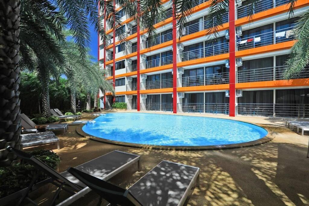 a swimming pool in front of a building at NEW one bedroom apartment MBC E in Ban Bo Sai Klang