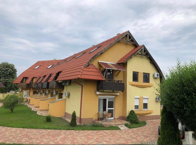 a large house with a red roof at Lagom Apartman in Gyula