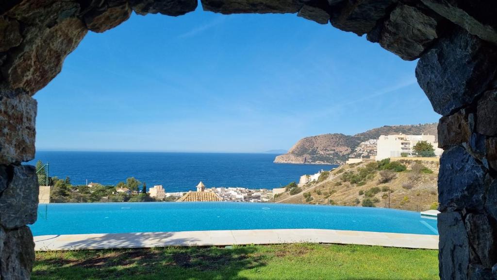 een uitzicht op een zwembad vanuit een stenen muur bij Casa Kalithea in La Herradura