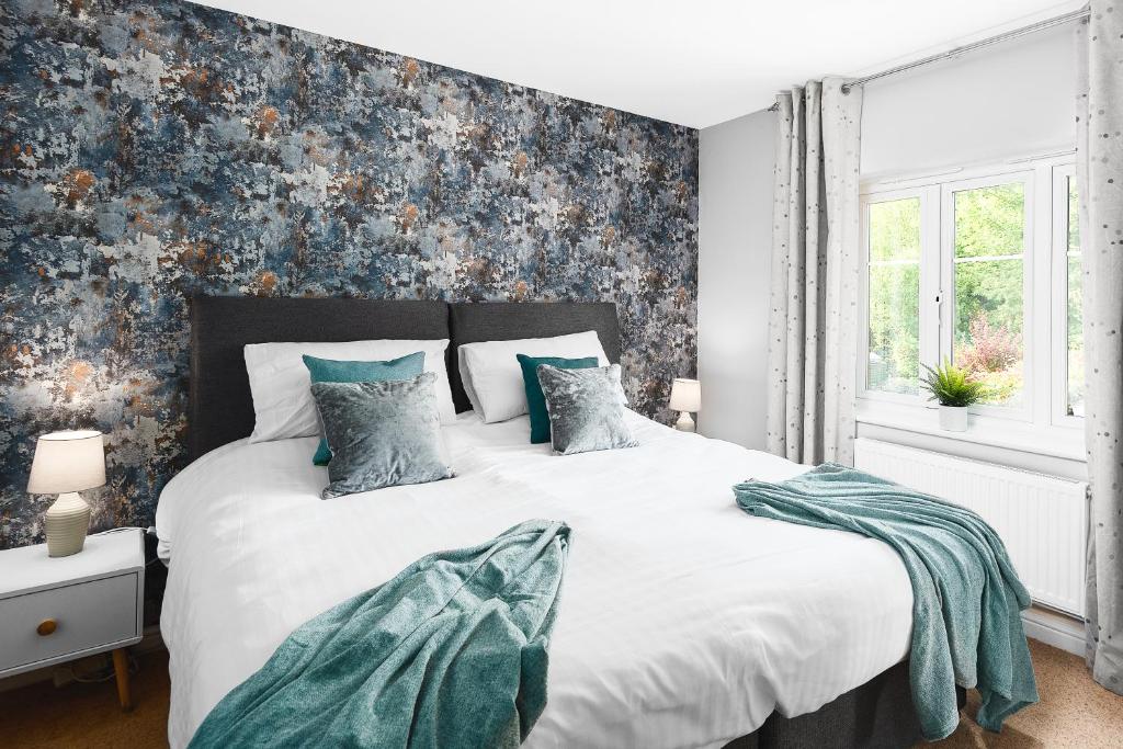 1 dormitorio con 1 cama blanca grande y pared azul en TravelNest Property en Bristol