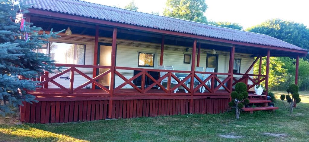 a large red and white cabin with a porch at U Adama in Retowo