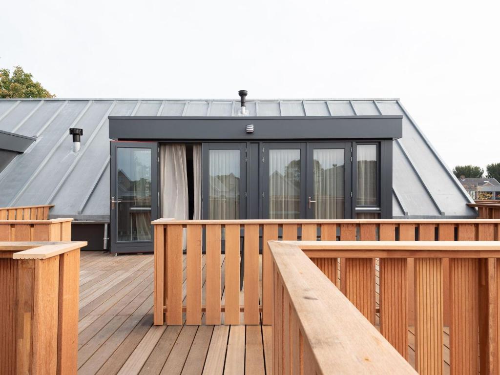 dom z drewnianym tarasem z czarnym dachem w obiekcie Luxury apartment in Renesse with infrared sauna w mieście Renesse