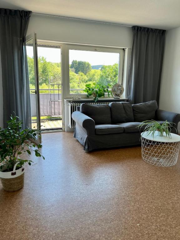 a living room with a couch and a large window at Ferienwohnung Wiesenblick in Illingen