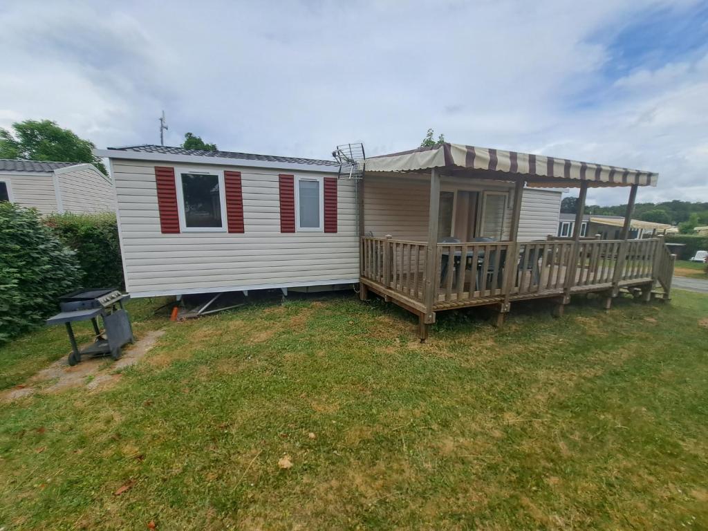 une petite maison avec un porche et une terrasse dans l'établissement Mobil Home neuf tout confort dans un camping 4 étoiles, à Onzain