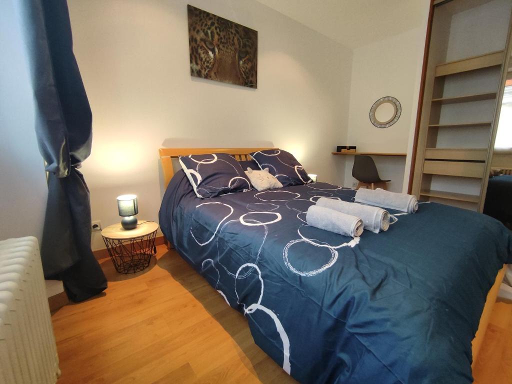 ein Schlafzimmer mit einem blauen Bett mit Kissen darauf in der Unterkunft Le Saint-Roch, Centre-ville, Terrasse privée in Issoudun