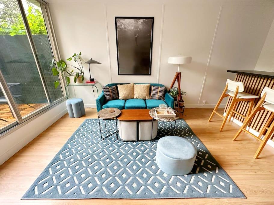 un salon avec un canapé bleu et un tapis dans l'établissement Secret Garden Étoile, à Paris