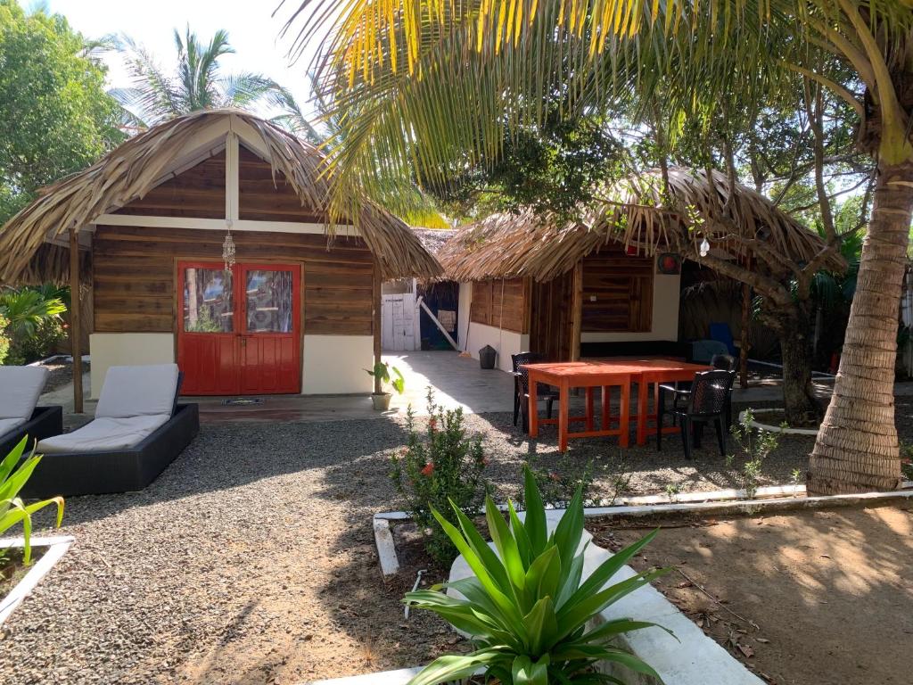 a cabin with a red door and a table and chairs at The Tasty Tuna Cabana in Arugam Bay