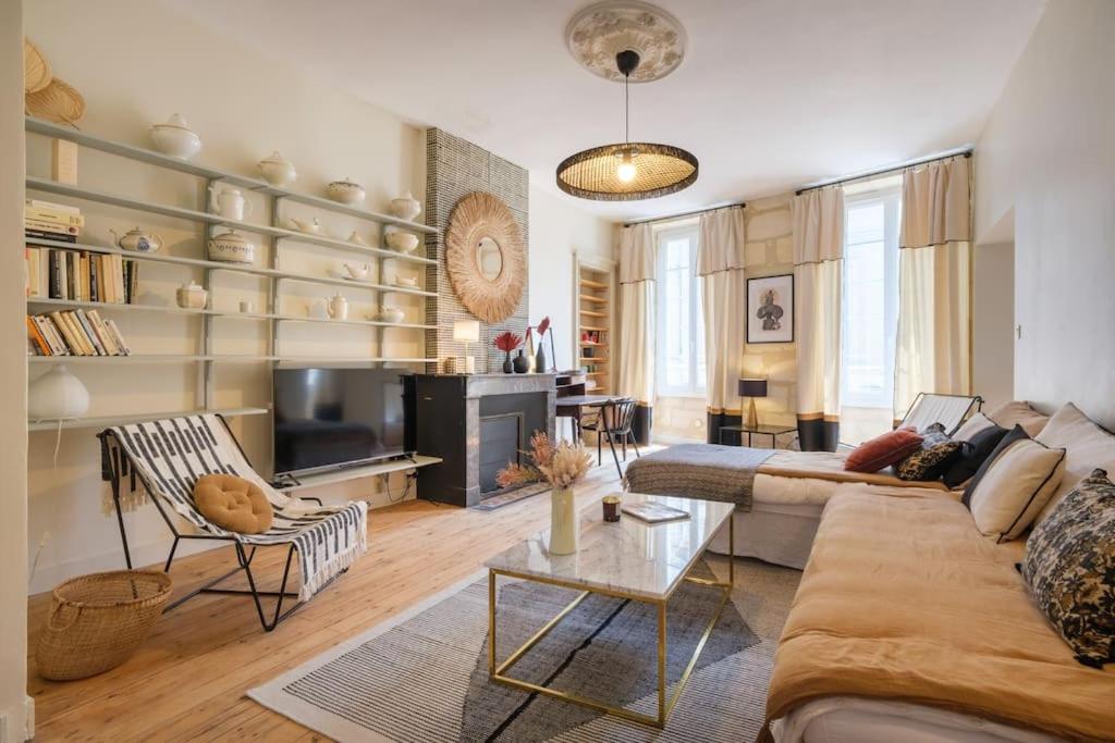 uma sala de estar com um sofá e uma mesa em Appartement avec son patio dans centre historique de Bourg em Bourg-sur-Gironde
