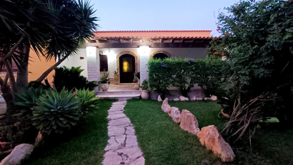 a house with a walkway in front of a yard at VILLA HELENA in Lampedusa