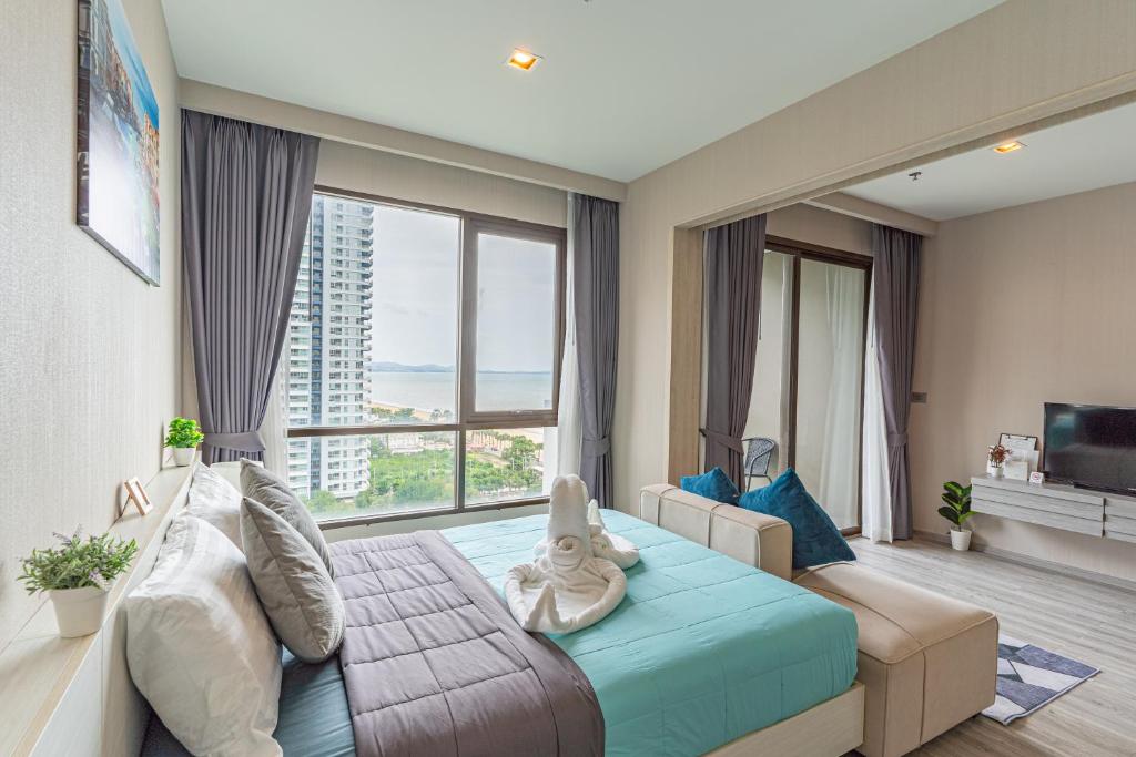 a hotel room with a bed and a large window at Aeras beachfront 1 bedroom in Jomtien Beach