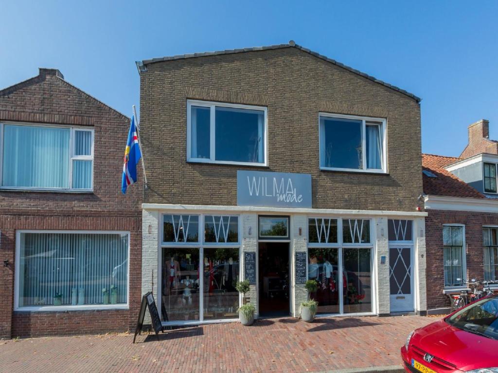 a brick building with a sign that reads willaan market at Lovely modern 4 person apartment in the heart of Koudekerke in Koudekerke