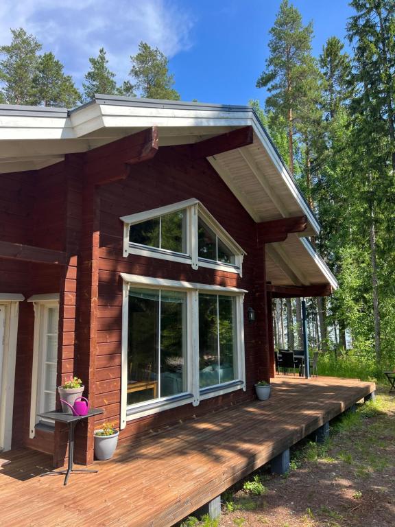 a house with a wooden deck in the woods at Holiday Home Amero purnu 4 in Kolinkylä