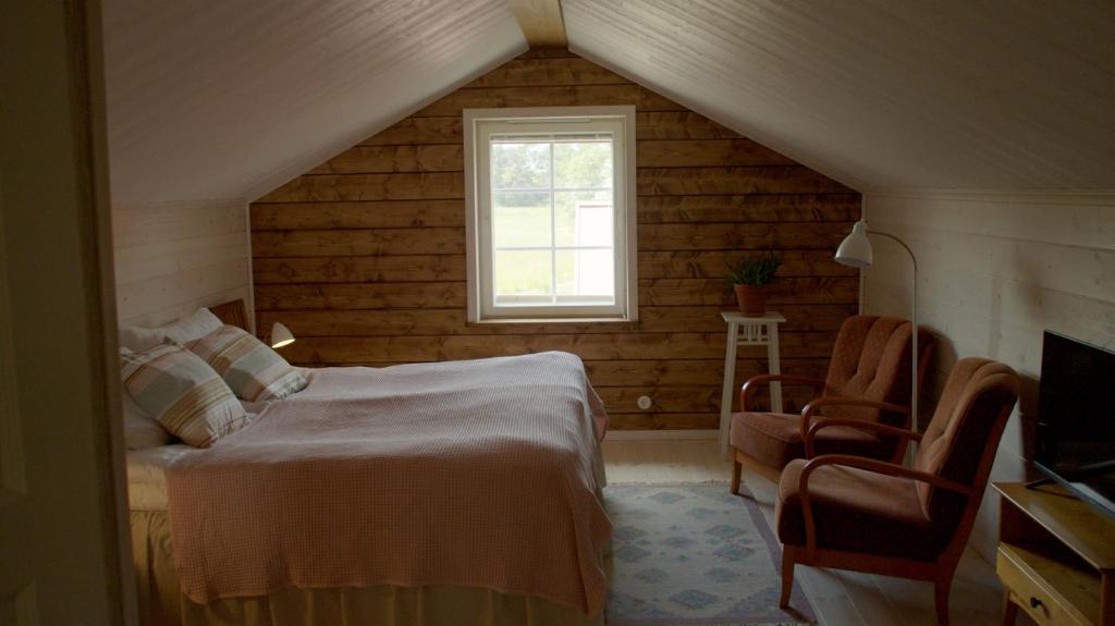 a bedroom with a bed and a window at Brändö Bike and Bed in Brändö