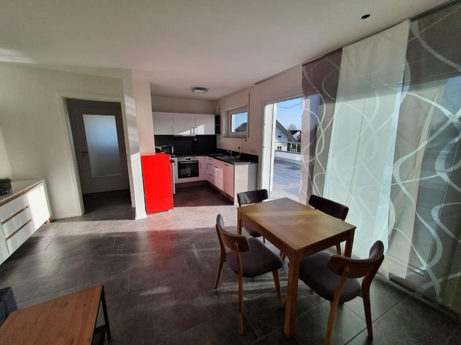 a kitchen with a table and chairs and a red refrigerator at Edle Ferienwohnung in Neubau in Riedlingen