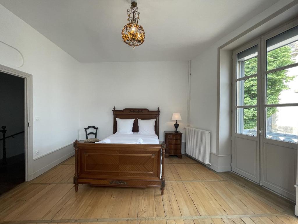 a bedroom with a bed and a chandelier at L&#39;appartement du Cellier in Pommard
