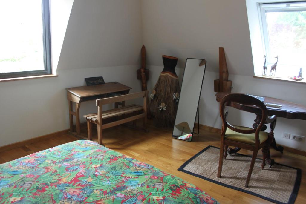 - une chambre avec un lit, un bureau et une chaise dans l'établissement Le TIVOLI, à Montignac