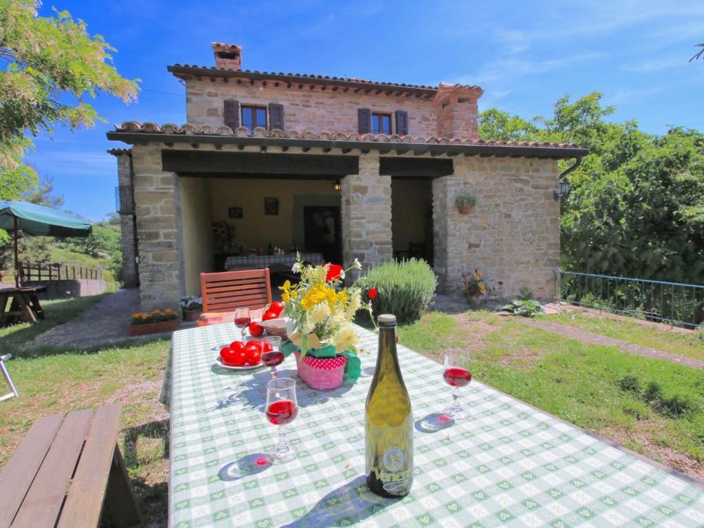 una mesa con una botella de vino y algunas flores en Farmhouse in Apecchio with Swimming Pool Terrace Garden, en Apecchio