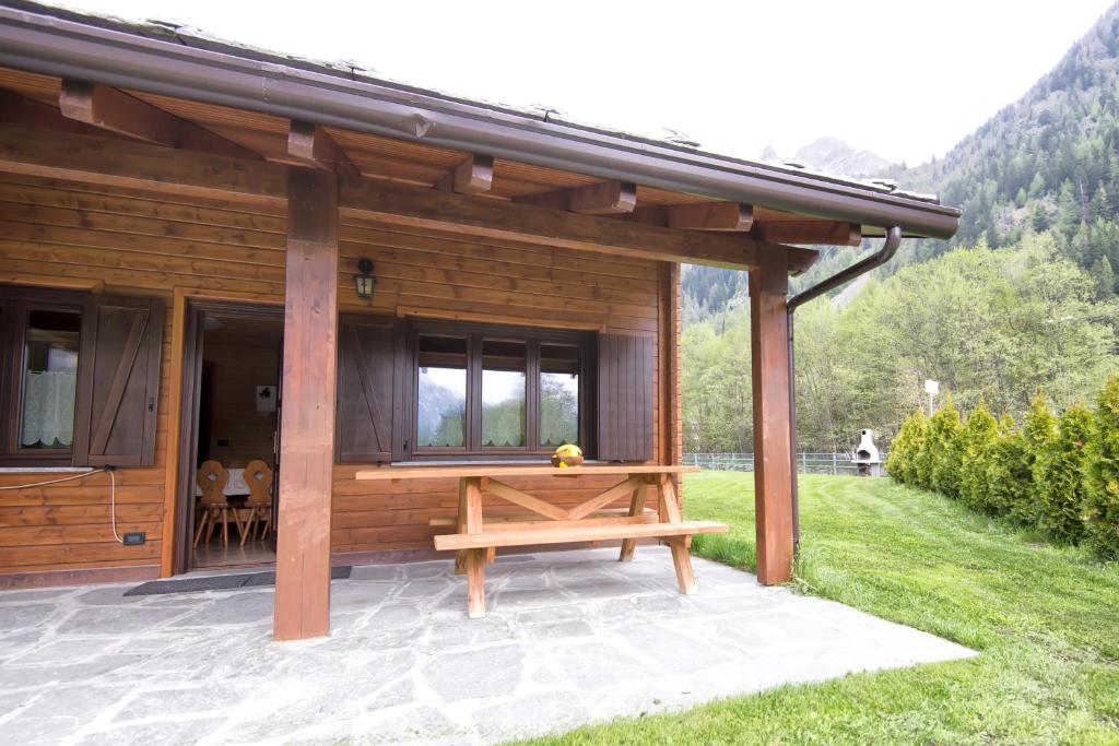 a wooden cabin with a picnic table on a patio at Margherita Camping & Resort in Gressoney-Saint-Jean