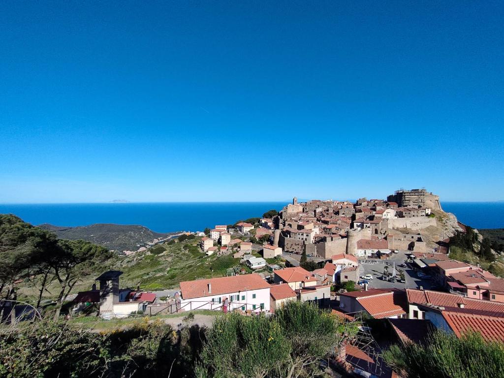 uma aldeia numa colina com o oceano ao fundo em Giglio Castello - alloggi Mario & Marta em Isola del Giglio