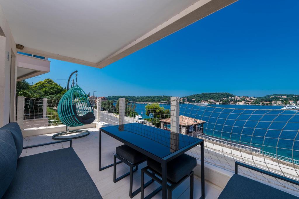 a balcony with a table and a view of the water at New Five Star Superior Apartment in Zaton