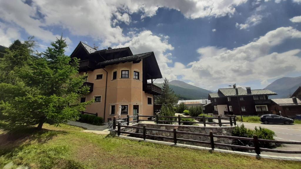 a house with a black roof and a fence at Chalet Rin da Pemont in Livigno