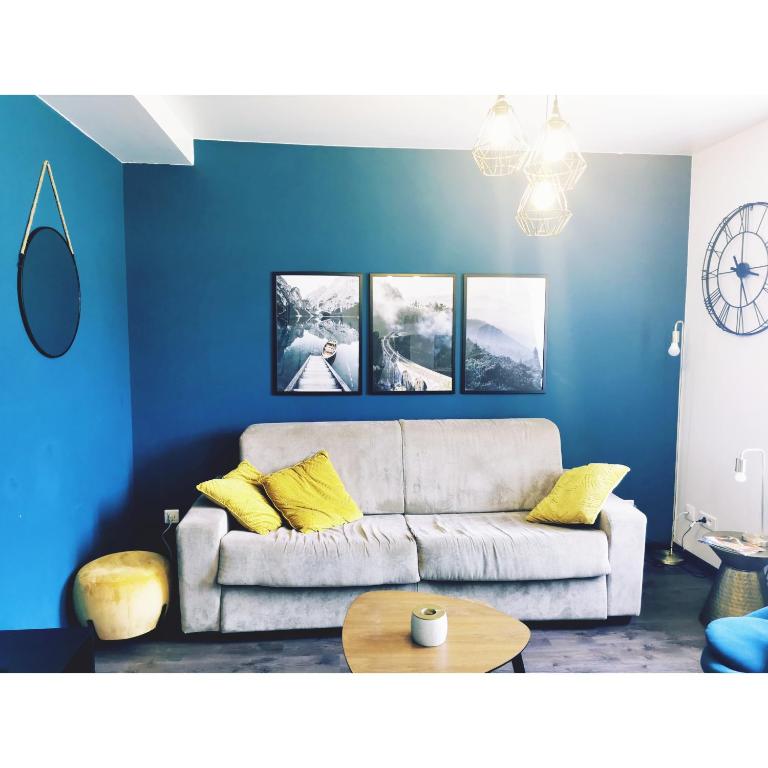 a living room with blue walls and a couch at L'émeraude in Le Bourg-dʼOisans