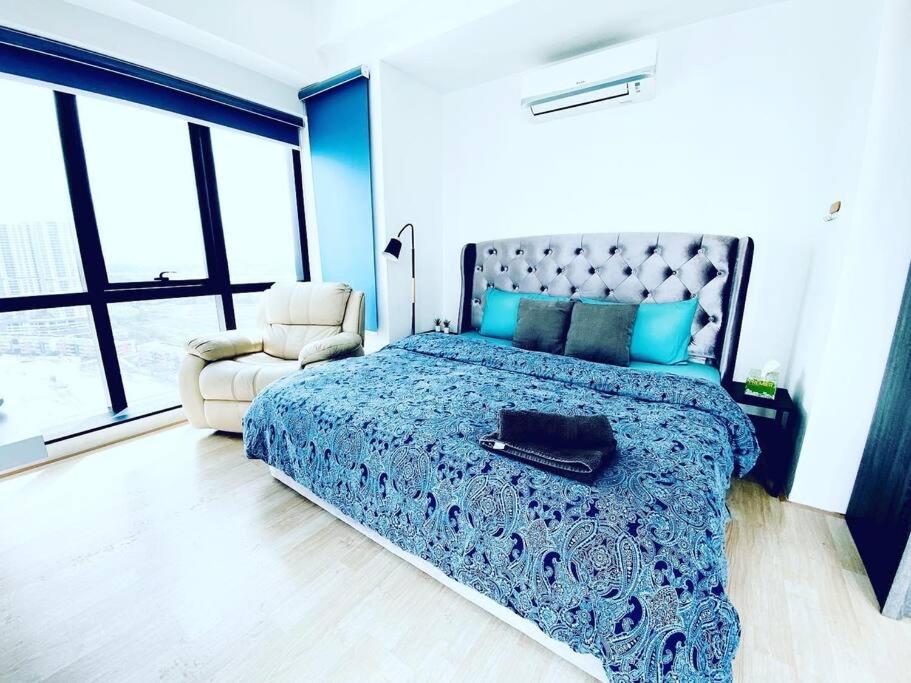 een slaapkamer met een bed, een stoel en ramen bij Super King-Sized Studio-Revo in Kuala Lumpur