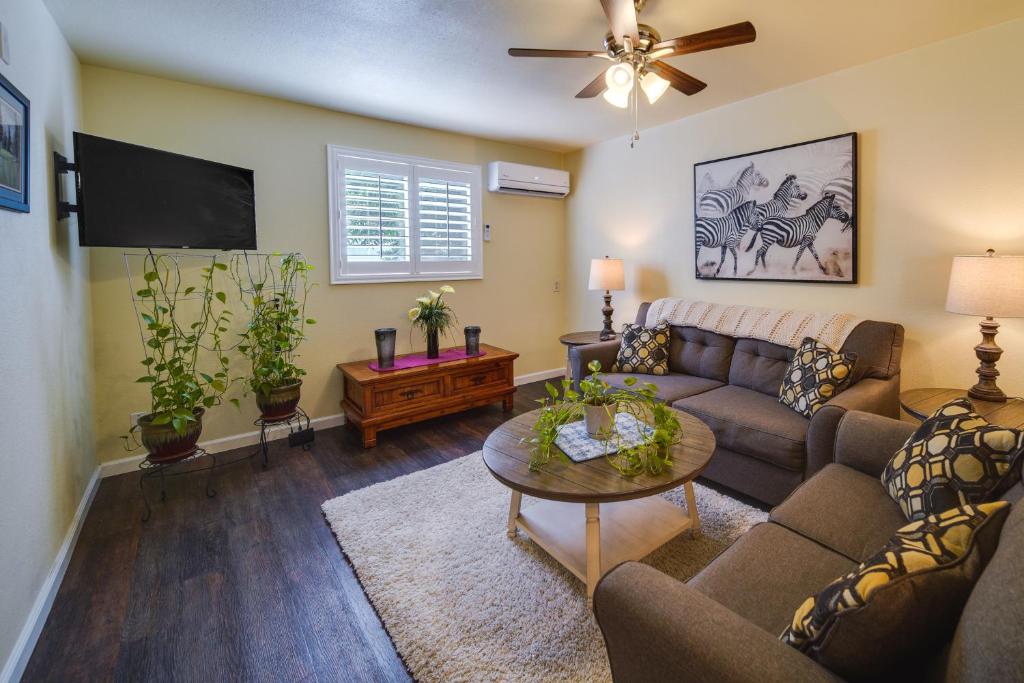 a living room with a couch and a tv at Sunny California Retreat with Pool Access and Patio! in Shasta Lake