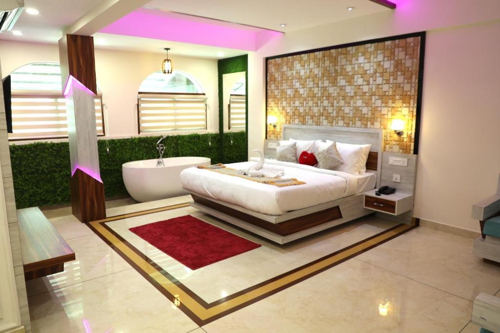 ROYAL CASTLE HOTEL في مانانثافادي: غرفة نوم بسرير كبير وحوض استحمام