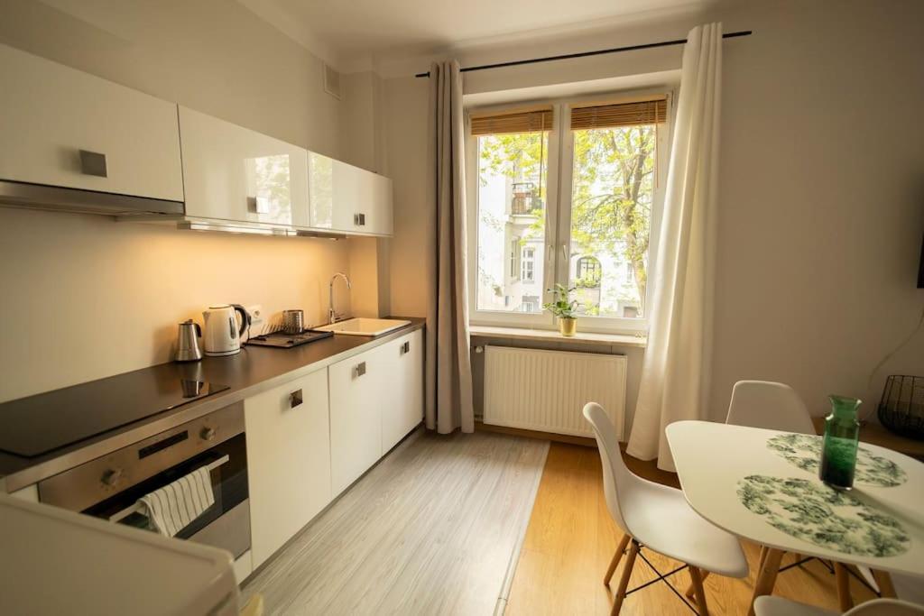 a small kitchen with a table and a window at Przytulne mieszkanie na ulicy Chmielna w samym centrum Warszawy in Warsaw