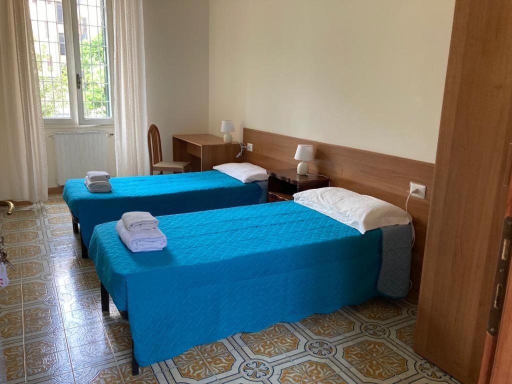 two beds in a hotel room with blue sheets at Interno 3 in Rome