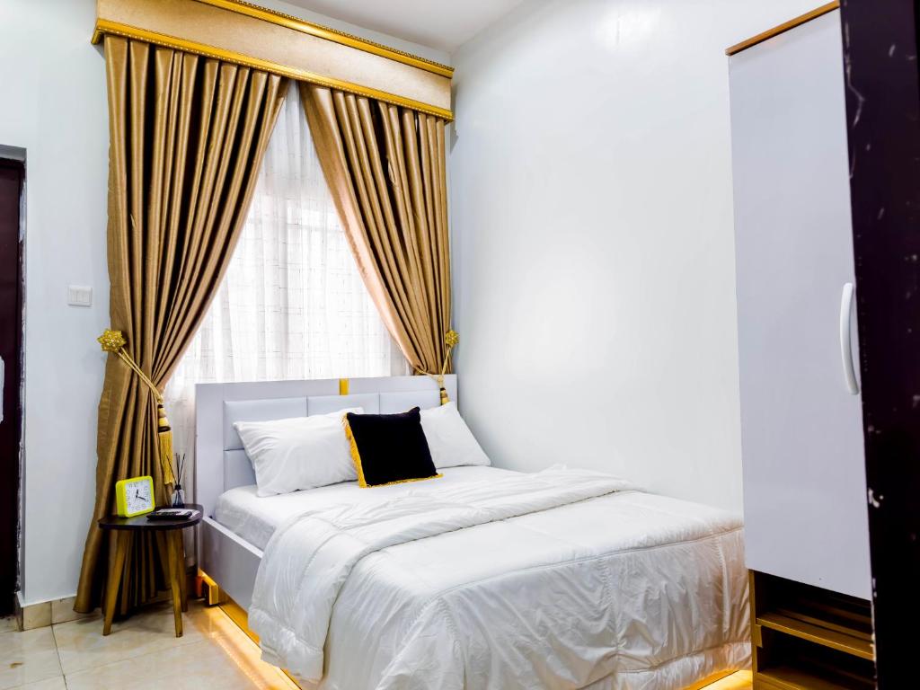 1 dormitorio con cama blanca y ventana en Cozy Apartment - Hideaway with 5G WiFi en Abuja