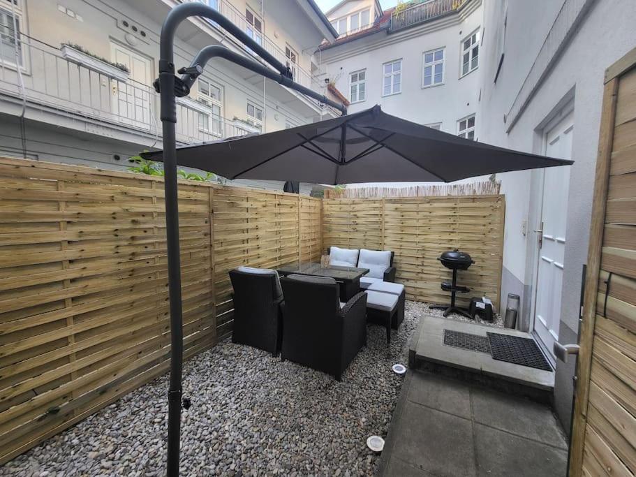 a patio with an umbrella and a table and chairs at Exklusive Gartenwohnung in Vienna