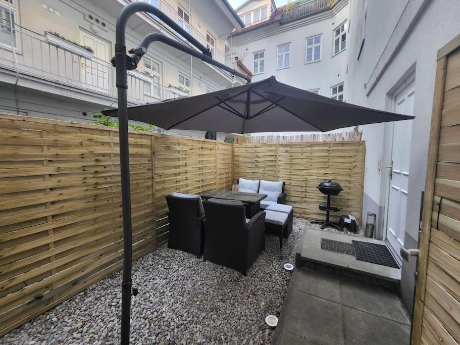 eine Terrasse mit einem Sonnenschirm, einem Tisch und Stühlen in der Unterkunft Exklusive Gartenwohnung in Wien