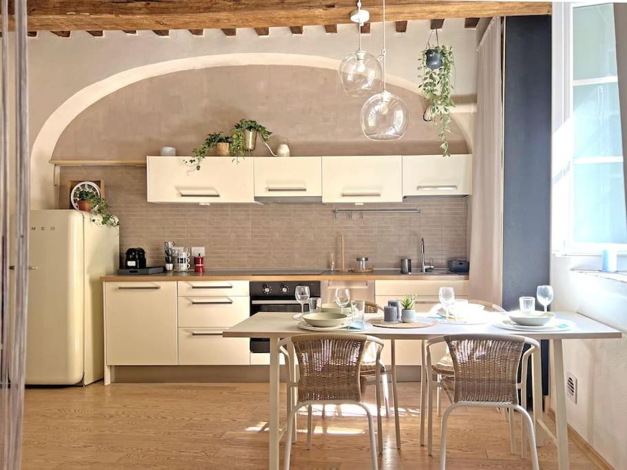 Una cocina con mesa y sillas y un refrigerador. en Suite 9, Parma Centro, en Parma