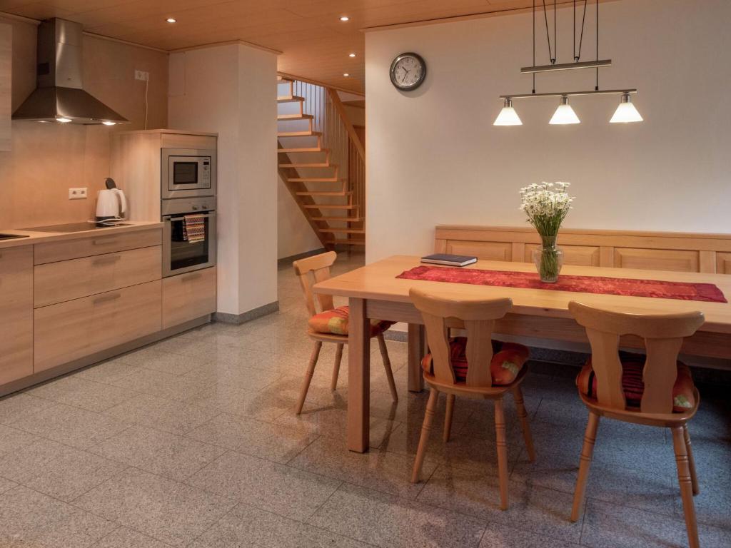 a kitchen and dining room with a wooden table and chairs at Cosy farmhouse apartment at the edge of the forest in Mühlenbach