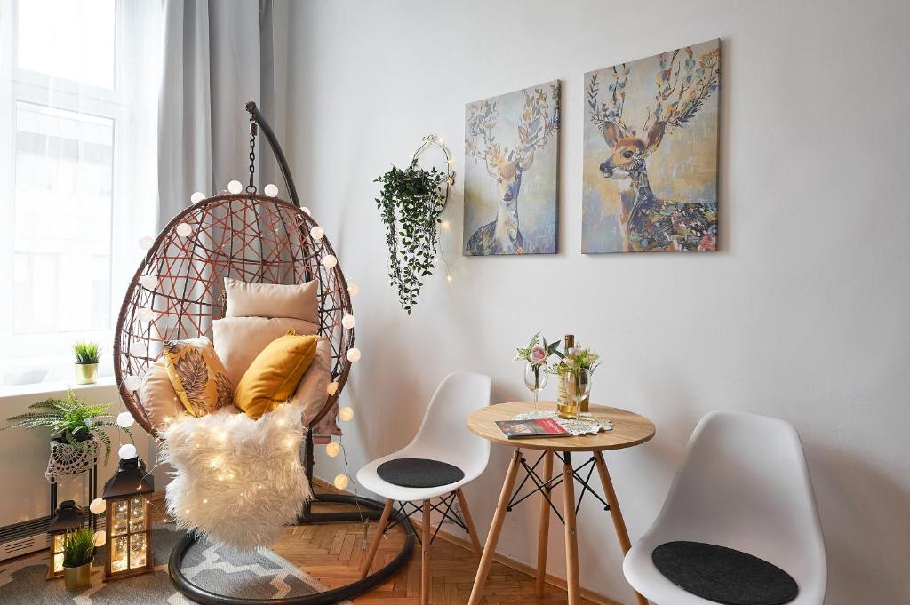 Apartments on Miodowa في كراكوف: غرفة بها كرسي ratan وطاولة