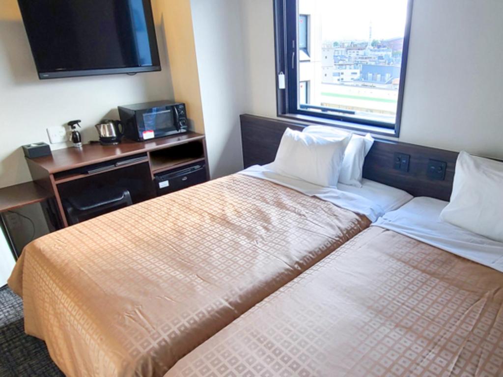 Postel nebo postele na pokoji v ubytování Hotel Livemax Premium Nagano Ekimae