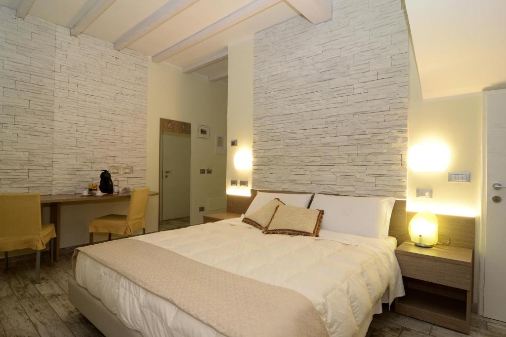 a bedroom with a large white bed and a table at Pidkova in Modena
