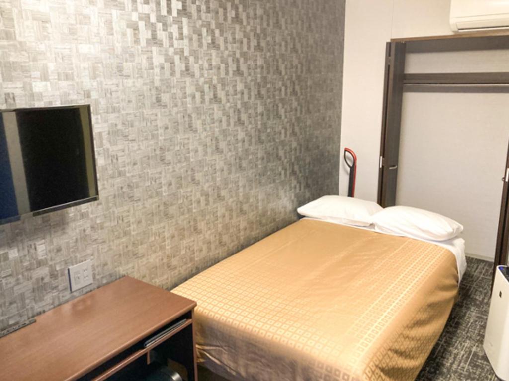 Postel nebo postele na pokoji v ubytování Hotel Livemax Premium Nagano Ekimae