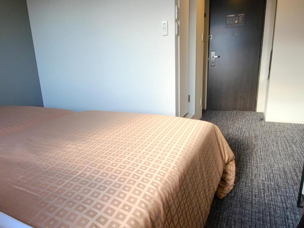 Postel nebo postele na pokoji v ubytování Hotel Livemax Premium Nagano Ekimae