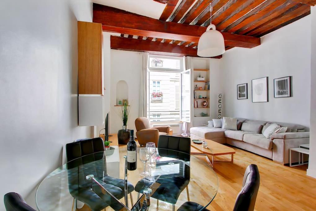 ein Wohnzimmer mit einem Glastisch und einem Sofa in der Unterkunft Unforgettable Stay in the Heart of Paris in Paris
