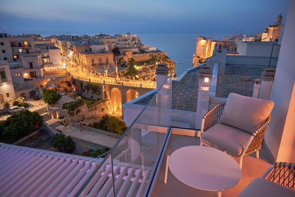 a balcony with a chair and a view of a city at White Coast in Polignano a Mare