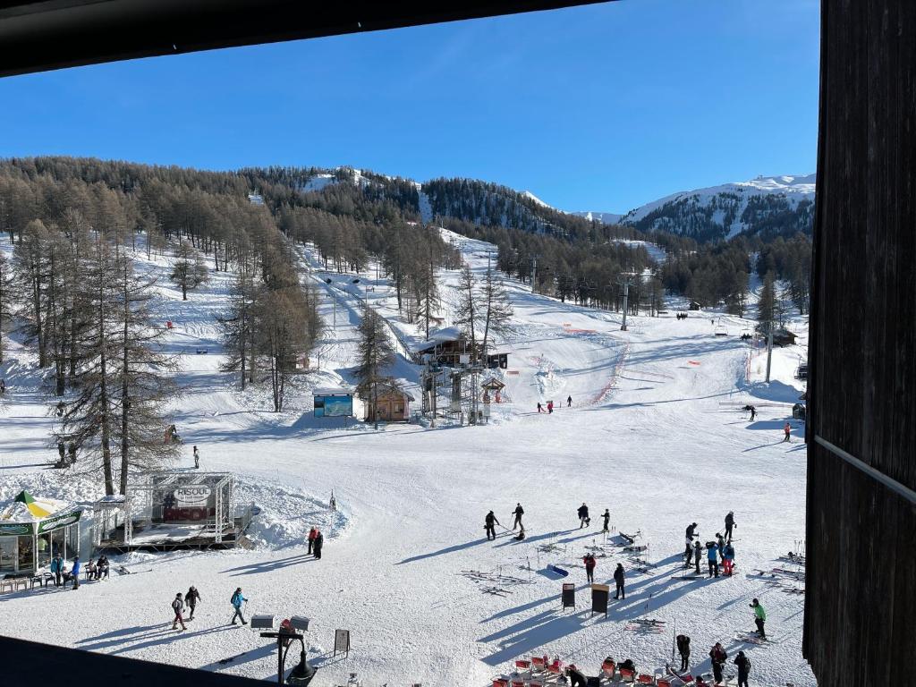 un groupe de personnes skier sur une piste de ski dans l'établissement Le cocon Risoul, à Risoul