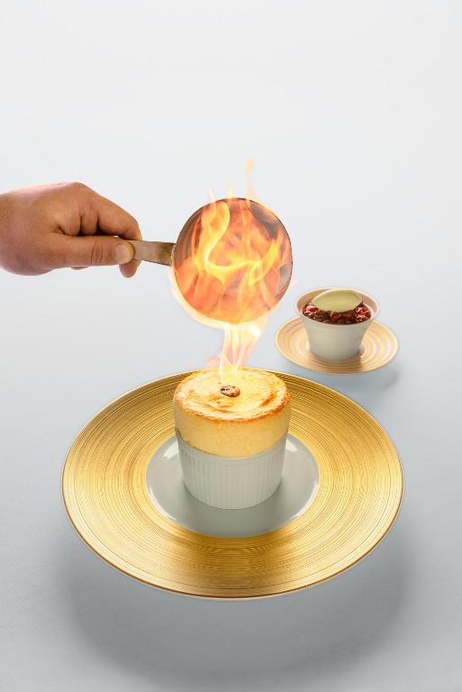 a person is cooking a dessert on a plate at Hôtel Royal in Évian-les-Bains