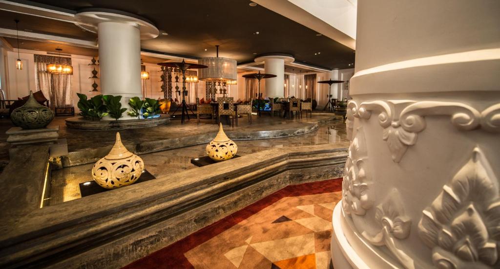 a lobby with vases on the floor of a building at Rose Garden Hotel in Yangon
