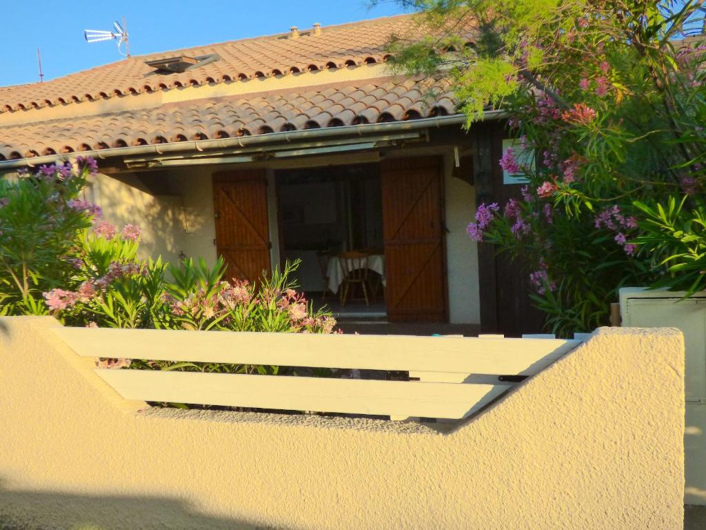 une maison avec un banc blanc devant elle dans l'établissement Charmante maison familiale à Gruissan avec terrasse ensoleillée, à Gruissan
