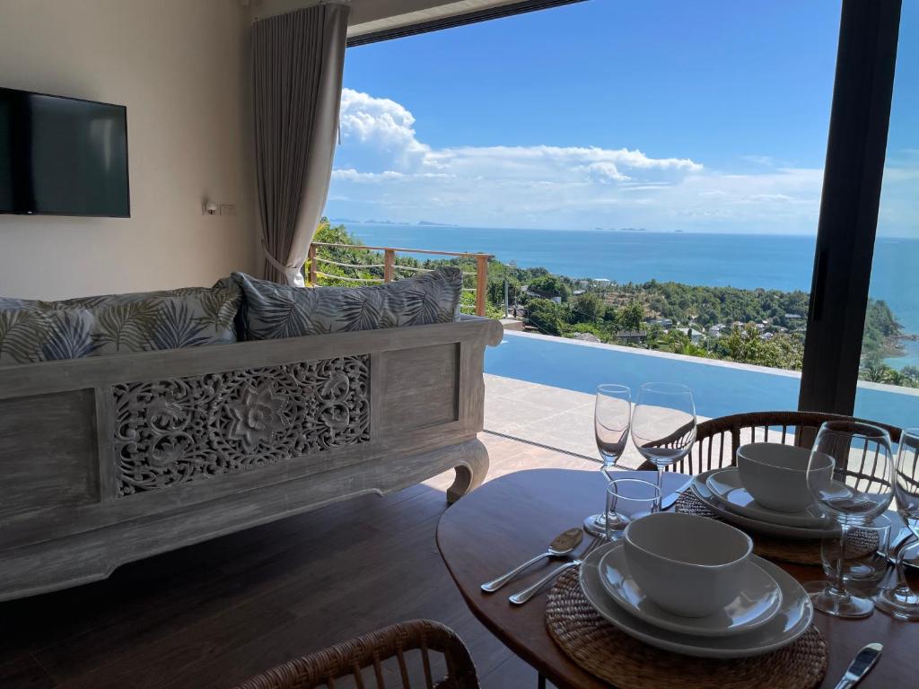 a dining room with a view of the ocean at LOLISEA Luxe view villas in Salad Beach