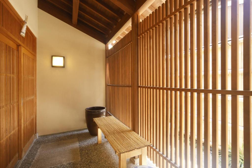a wooden bench in a room with wooden windows at Towa Ryokan in Kyoto